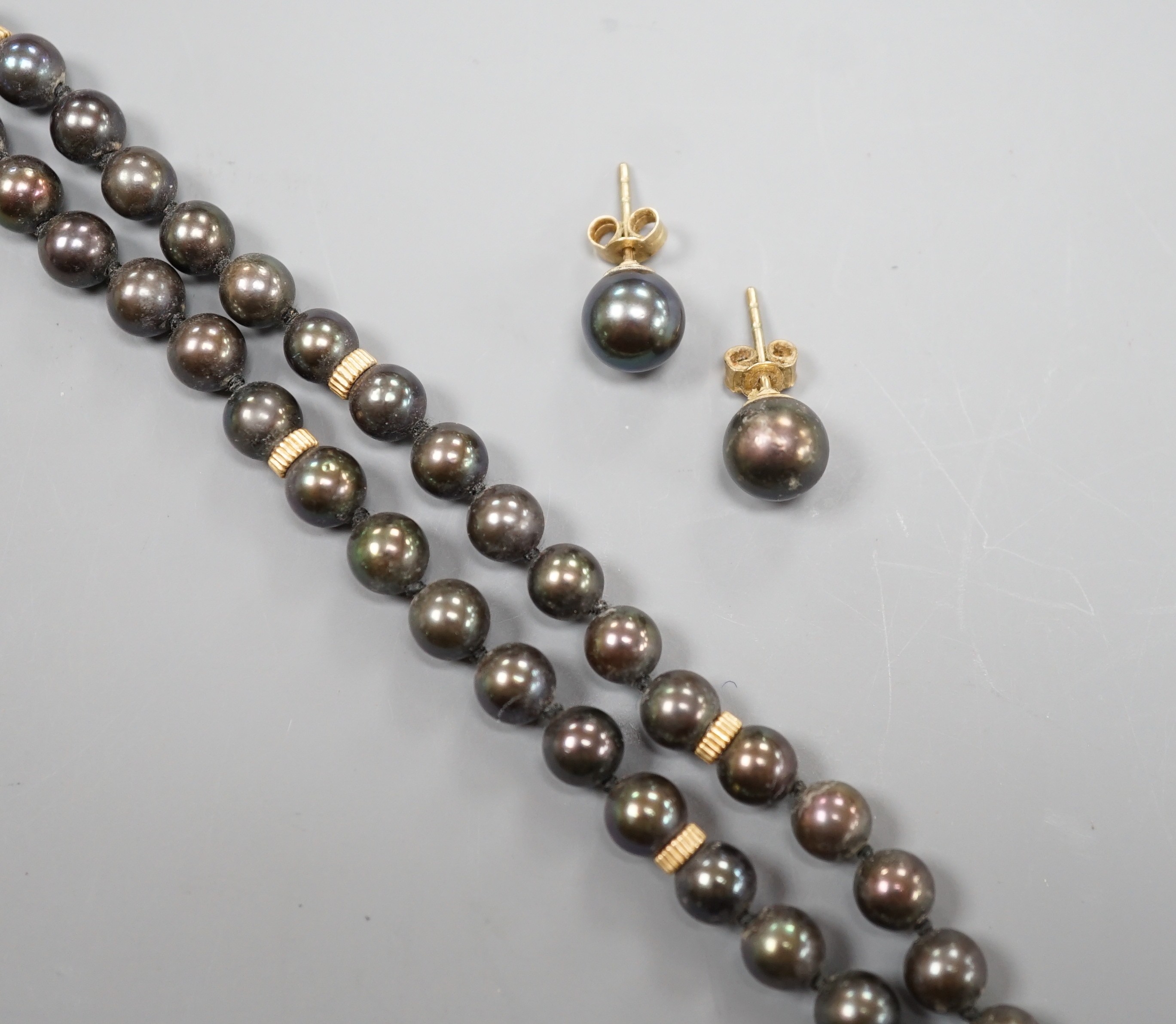 A single strand Tahitian cultured pearl necklace, with yellow metal spacers and a 14k yellow metal clasp, 47cm, together with a similar pair of 375 earrings.